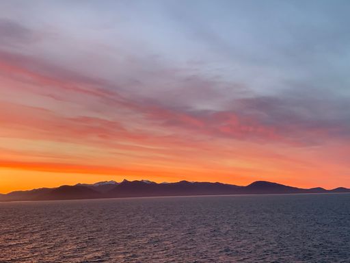 A beautiful orange cloudy sky over the tranquil sea, moments before the sunset