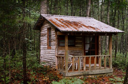 A small old wooden house on a gloomy day in the dense forest of Northern Michigan