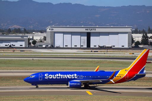 A view of the Southwest Airlines Boeing 737-800 taxiing to the gates at SJC with NetJets hangar and Santa Cruz mountains in the background