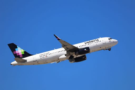 A view of the Volaris Airbus A320 taking off from San Jose International Airport with landing gear retracting, heading to Zacatecas
