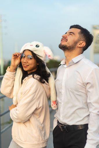A vertical shot of a nice couple standing on an old bridge on a windy day in Saigon, Vietnam