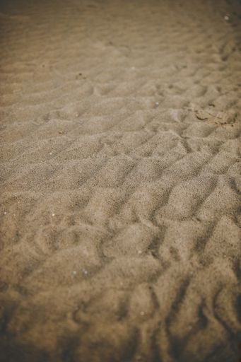 A vertical shot of wrinkles on the sand of the beach