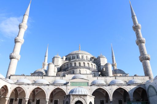 The iconic Blue Mosque in Istanbul, Turkey, with its majestic domes and minarets against a clear blue sky.