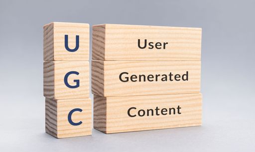 A close up of an UGC User Generated Content text on wooden blocks on gray background.