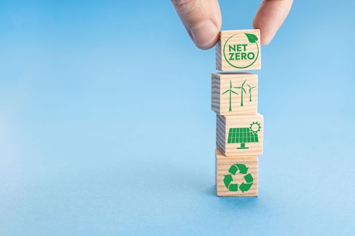 A net Zero and Carbon Neutral Concept. Hand putting wood block with Net Zero icon on top of others with green energy icons.