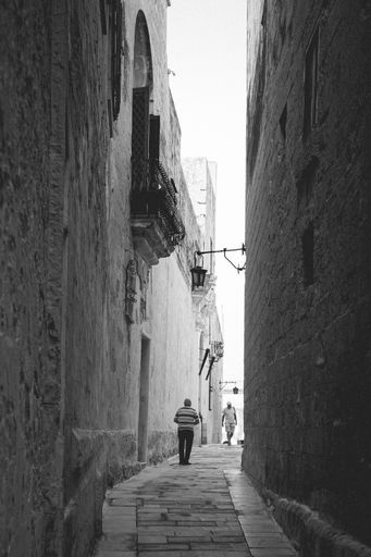 A vertical shot of an alley surrounded by two buildings in Malta