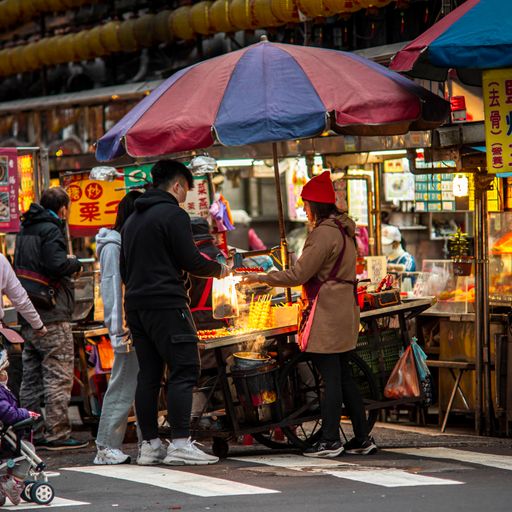 A man buying street food with a woman in Keelung, Taiwan