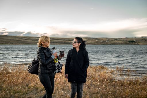 A shot of the two Caucasian females talking and drinking Yerba mate next to the beach in Argentina
