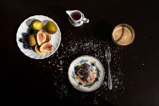 A delicious dessert on a plate with syrup and figs on a black table