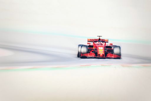 A red Ferrari in formula one testing on a street
