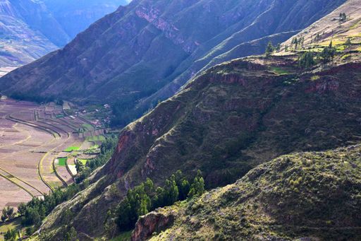 A stunning aerial view shows steep mountainsides descending into a green valley below.