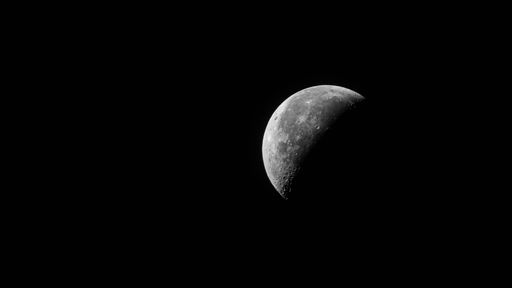 The gibbous waning phase of the moon against a black background at nigh