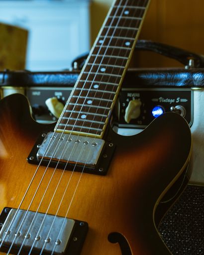 A closeup vertical shot of a brown electronic guitar