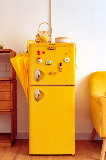 A vertical shot of a small yellow fridge