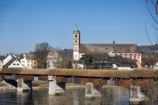 A historic wooden bridge over the Rhine River in Bad Sackingen, Germany, with a church