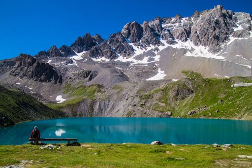 A Mesmerizing view of beautiful snowy hills and a small lake with blue sky in the background