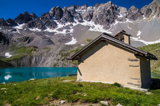 A Mesmerizing view of beautiful snowy hills and a small lake with blue sky in the background
