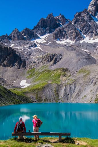 A vertical shot of people sitting near the Lake Sainte Anne in hautes alpes. Queyras, France
