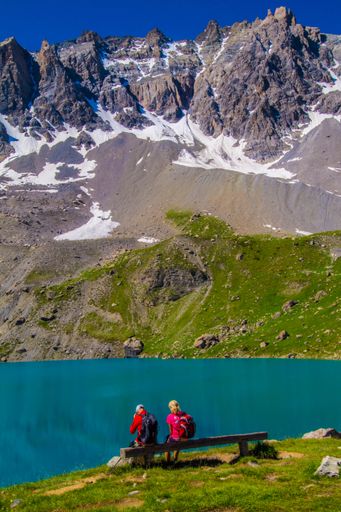 A vertical shot of people sitting near the Lake Sainte Anne in hautes alpes. Queyras, France