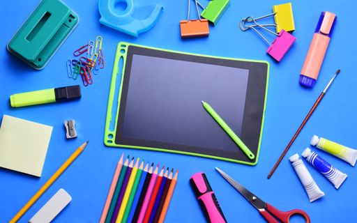 A variety of school supplies, hydroalcoholic gel, and surgical masks on a light-colored background