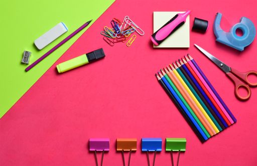 A variety of school supplies, hydroalcoholic gel, and surgical masks on a light-colored background