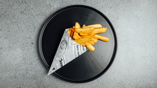 A top view of french fries served on a black plate