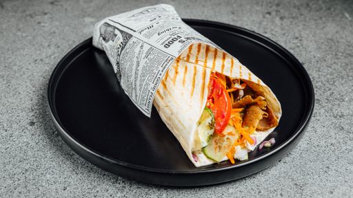 A closeup shot of tasty shawarma served on a black plate