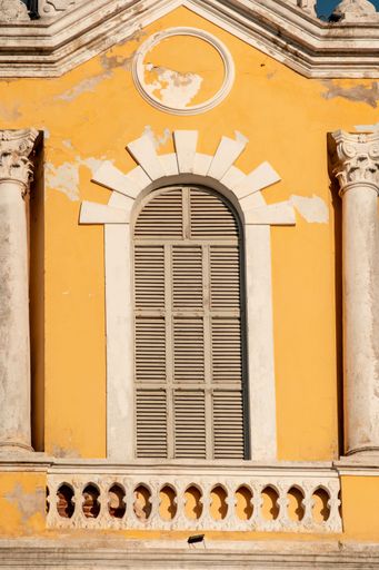 A vintage yellow building facade with ornate architectural details