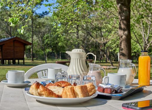 An Argentine breakfast in the garden on holiday, biscuits, croissants, jugs of milk, chocolate milk, orange juice