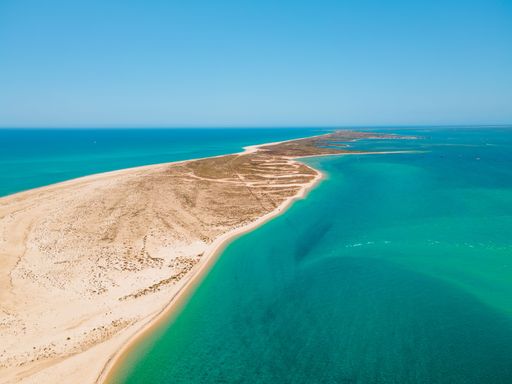 Aerial view of Ilha da Culatra island with turquoise waters and sandy beaches in Algarve, Portugal.