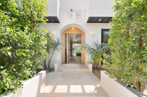 Architecturally refined home with open-concept interiors, custom woodwork, seamless indoor-outdoor flow, and lushly landscaped yard with pool.