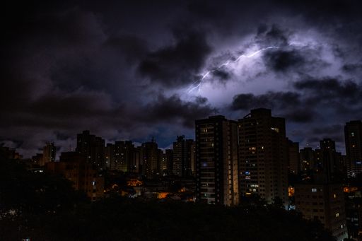 An amazing shot of a cityscape on dark clouds and lightning background