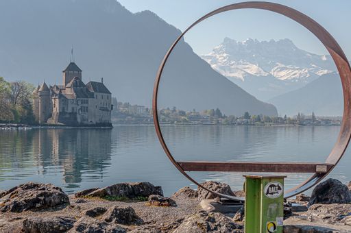 A beautiful shot of Chillon Castle in Lake Geneva, Veytaux, Switzerland with tall mountains in the background