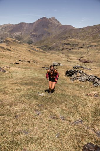 A vertical shot of a Hispanic girl hiking in nature on a sunny day
