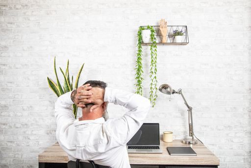 A bearded man working from home in front of his desk with a laptop