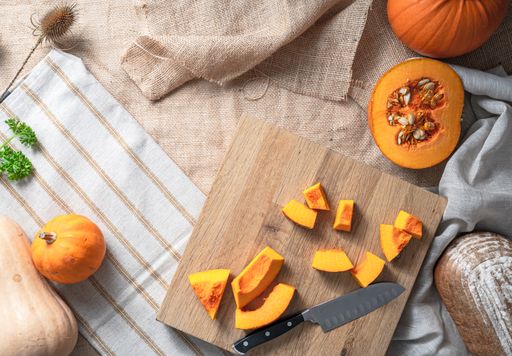 A top view of the makings of a delicious pumpkin soup and bread
