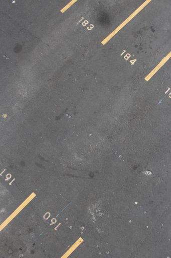 A vertical shot of a parking lot with numbers and yellow lines