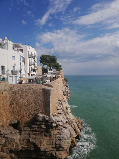 A vertical shot of a beach and buildings on the rock. Peniscola, Spain