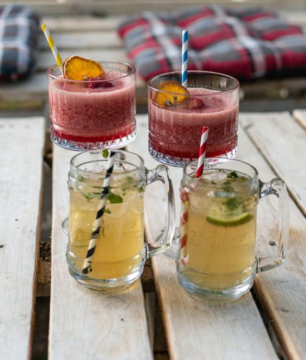 Two mojitos and strawberry daiquiris with colorful straws served at the cafe