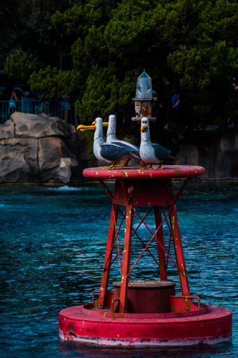 A vertical shot of seagulls' statues in the river in the amusement park