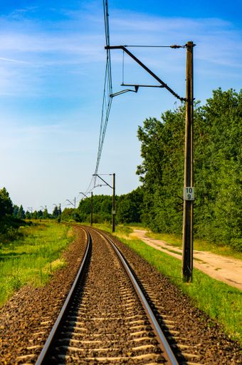 A vertical shot of an empty train railway on a sunny day