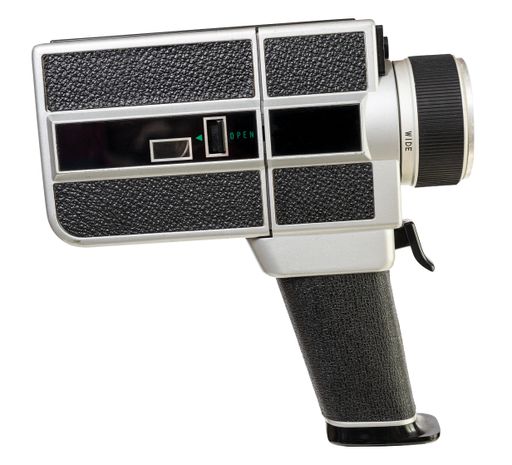 Vintage super 8 film camera isolated on white background. Side view