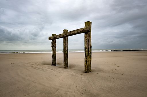 An old wooden poles construction on a sandy beach