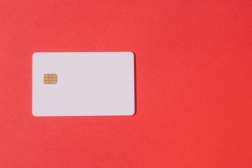 A top view of a blank smart card on a red table with a copy space