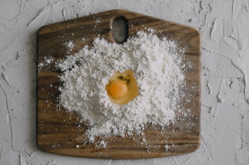 A high angle shot of an egg in flour on a chopping board