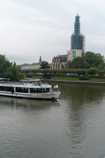 A vertical shot of a ship in the Main river b on a gloomy day in Frankfurt, Germany