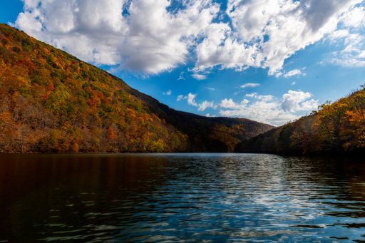 The calm pond or lake against the cloudy sky in autumn