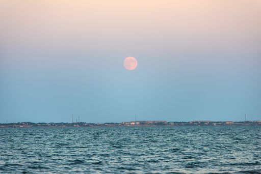 The moon over the sea during sunset