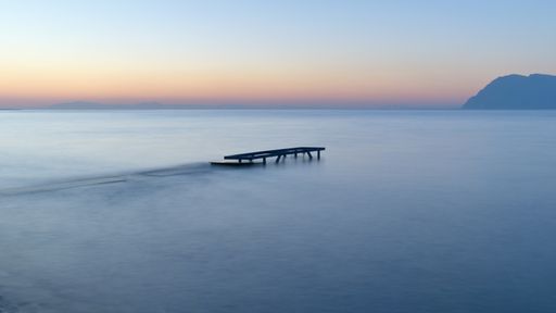 A beautiful view of a blue tranquil sea on a sunset