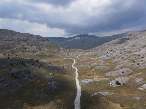 An aerial view of a valley going through the rocky mountains